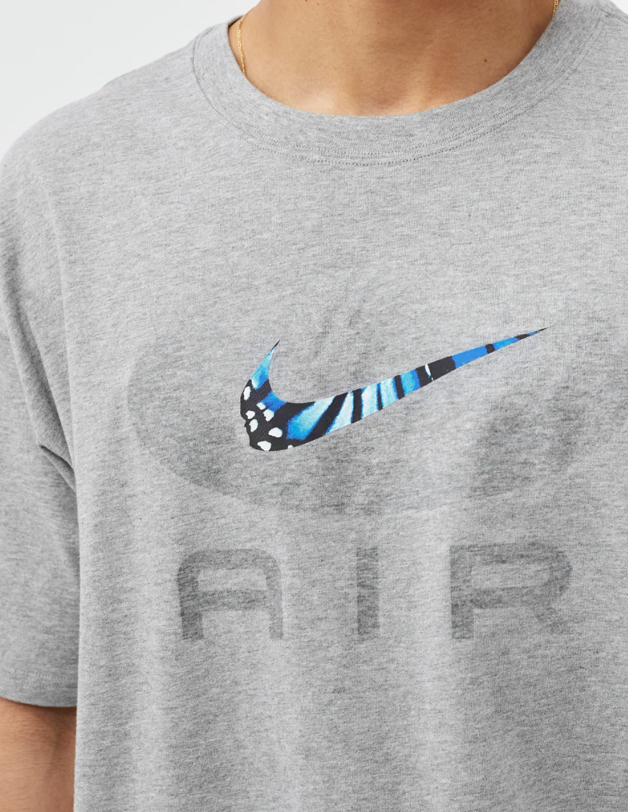 Boczny widok szarej męskiej koszulki Nike The Tee Butterfly DO6631-063 M z luźnym rękawem