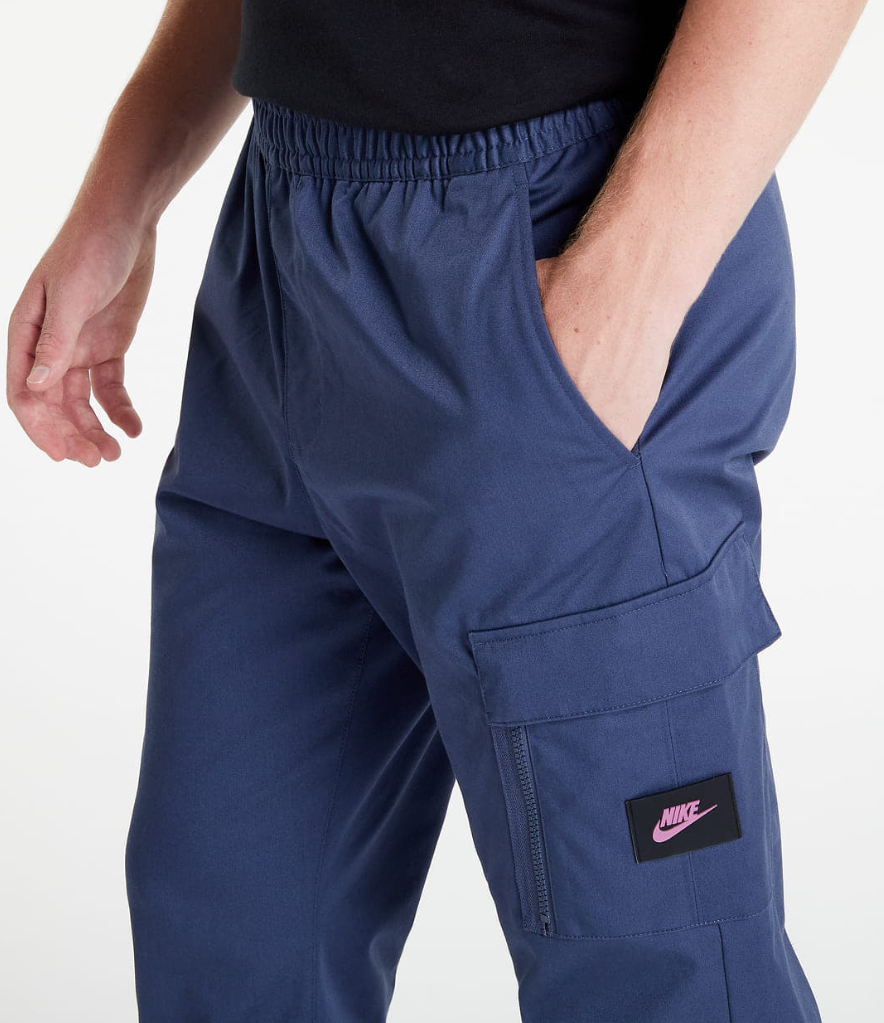 Boczny widok niebieskich męskich spodni cargo Nike DV1127437 XS z ściągaczami na nogawkach