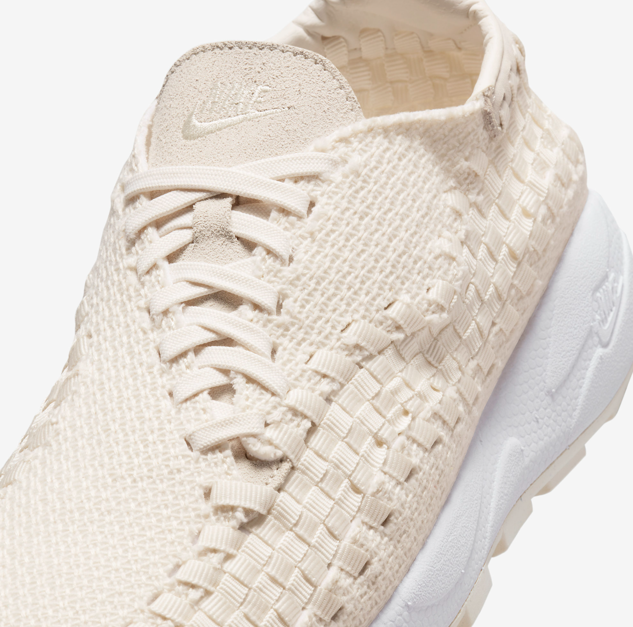 Boczny widok beżowych damskich butów Nike Air Footscape Woven FZ0405-001 45 z asymetrycznym sznurowaniem i ergonomicznym kształtem