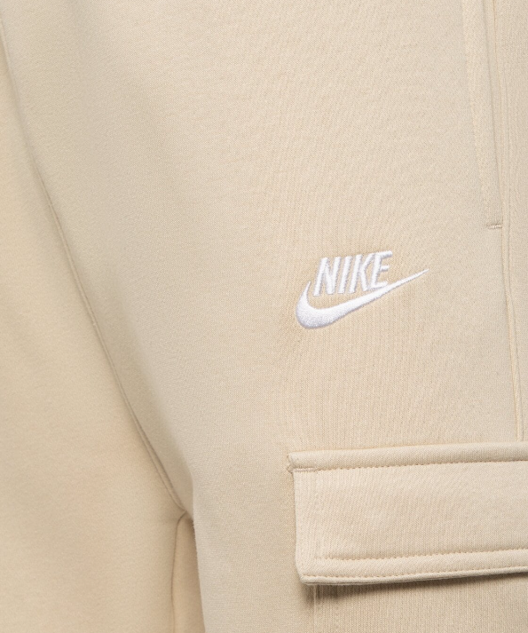 Boczny widok beżowych męskich spodni Nike Sportswear Club Fleece CD3129-206 L ze ściągaczami