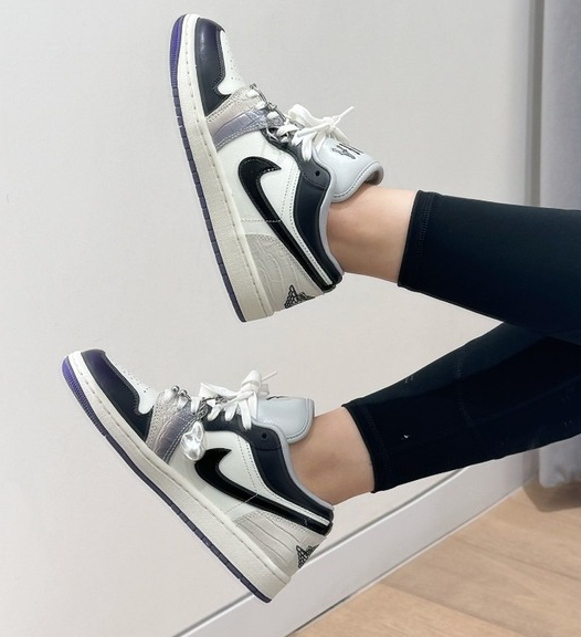 Boczny widok czarno-białych damskich butów Nike Air Jordan 1 Low SE Punk Rock HF5759-101 41 z fioletową podeszwą i zawieszkami