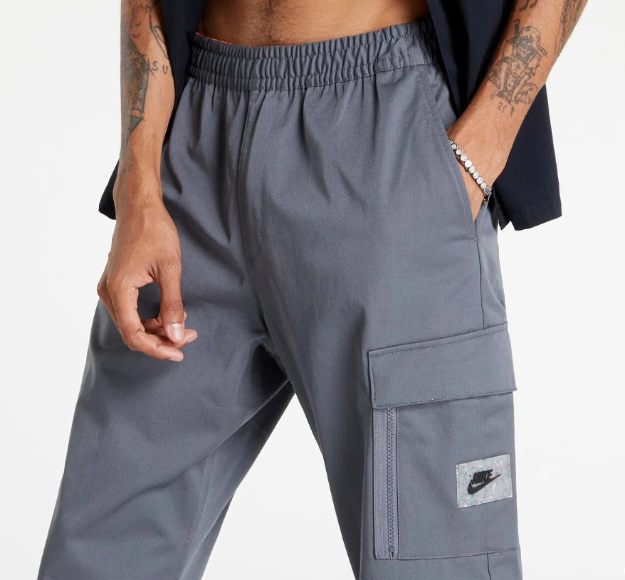 Boczny widok szarych męskich spodni Nike Sportswear Woven Cargo DV1127-063 XXL ze zwężanymi nogawkami