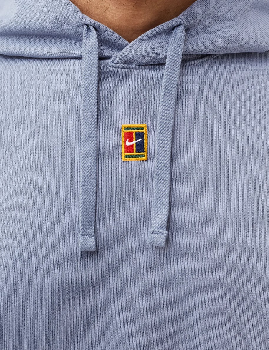 Boczny widok niebieskiej męskiej bluzy Nike Court Fleece Tenisowa Dri-Fit DA5711-493 XL z regulowanym kapturem