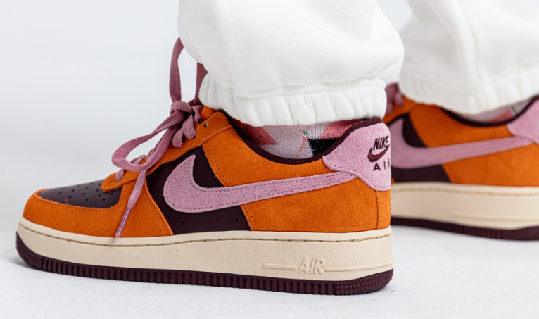 Boczny widok pomarańczowo-brązowych damskich butów Nike Air Force 1 '07 Magma Orange DZ5629-800 44 z fioletowymi sznurówkami