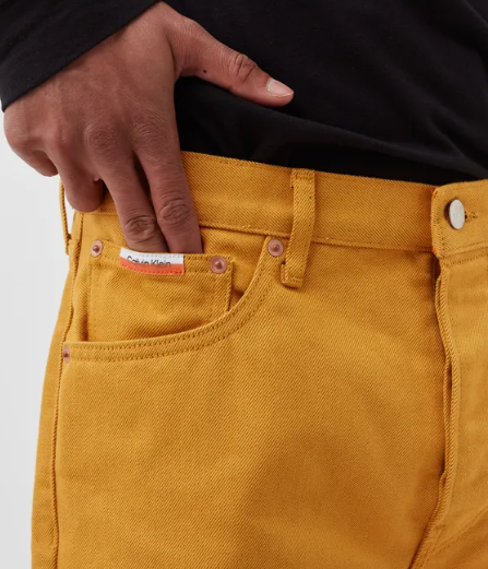 Pomarańczowe spodnie męskie Calvin Klein Straight Leg K10K109178ZCE 32 bok z pomarańczową naszywką