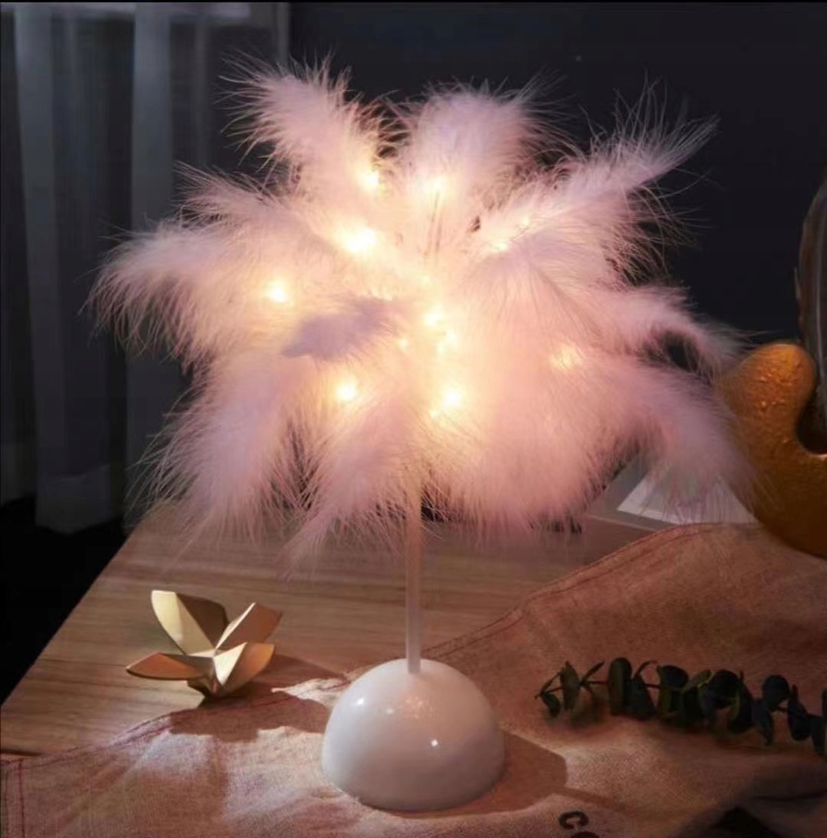a white feathered object with lights on top of it