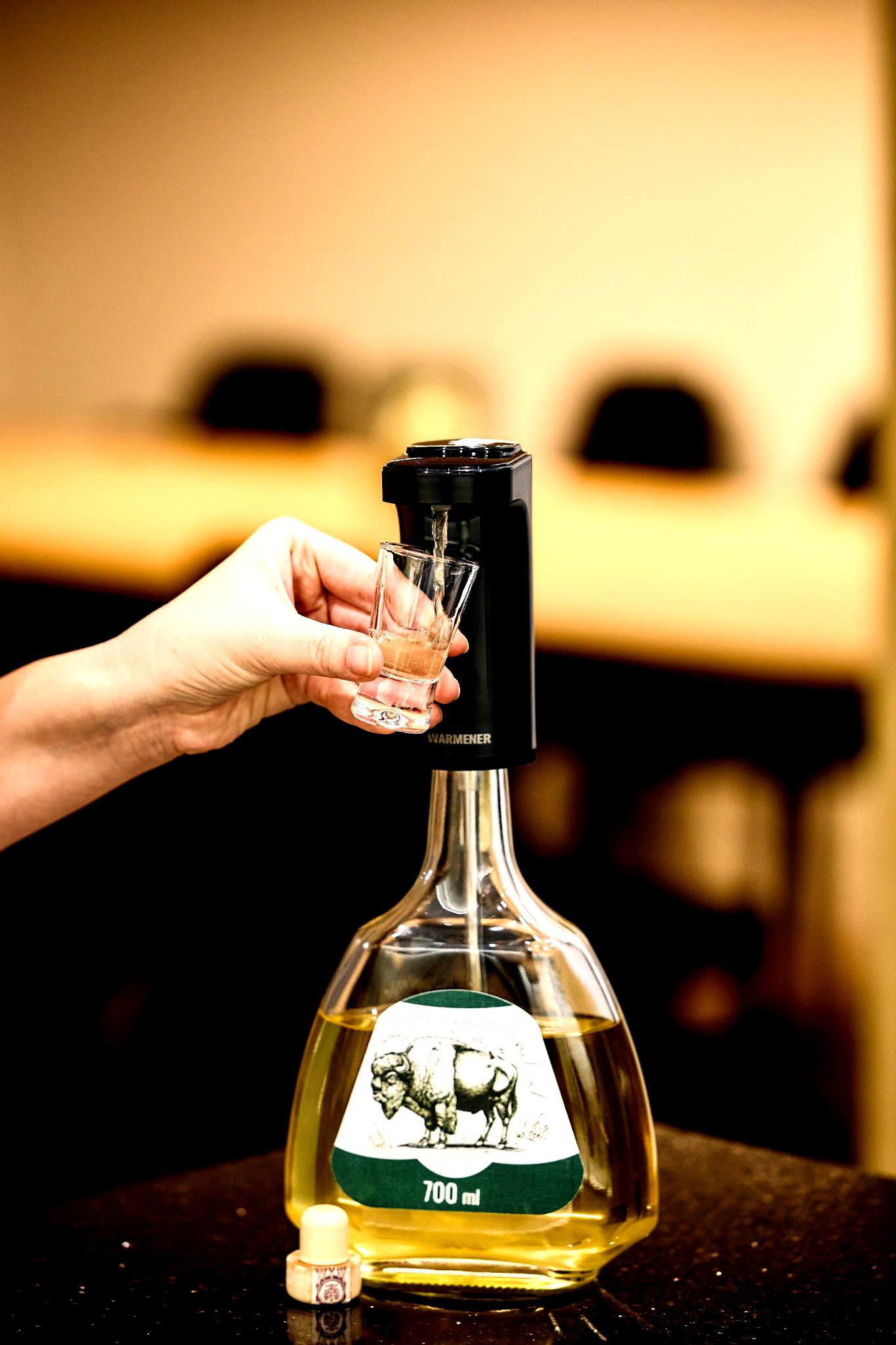 Dyspenser i aerator Warmener™ podczas nalewania wina do kieliszka