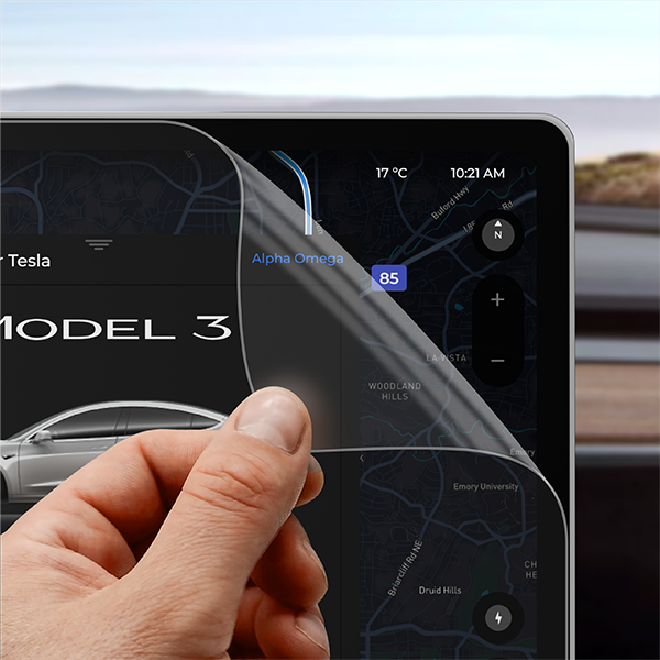 A hand peels GrizzProtector Displayschutzfolie Matt for Tesla Model 3 Highland (2023-2024) from a touchscreen display.