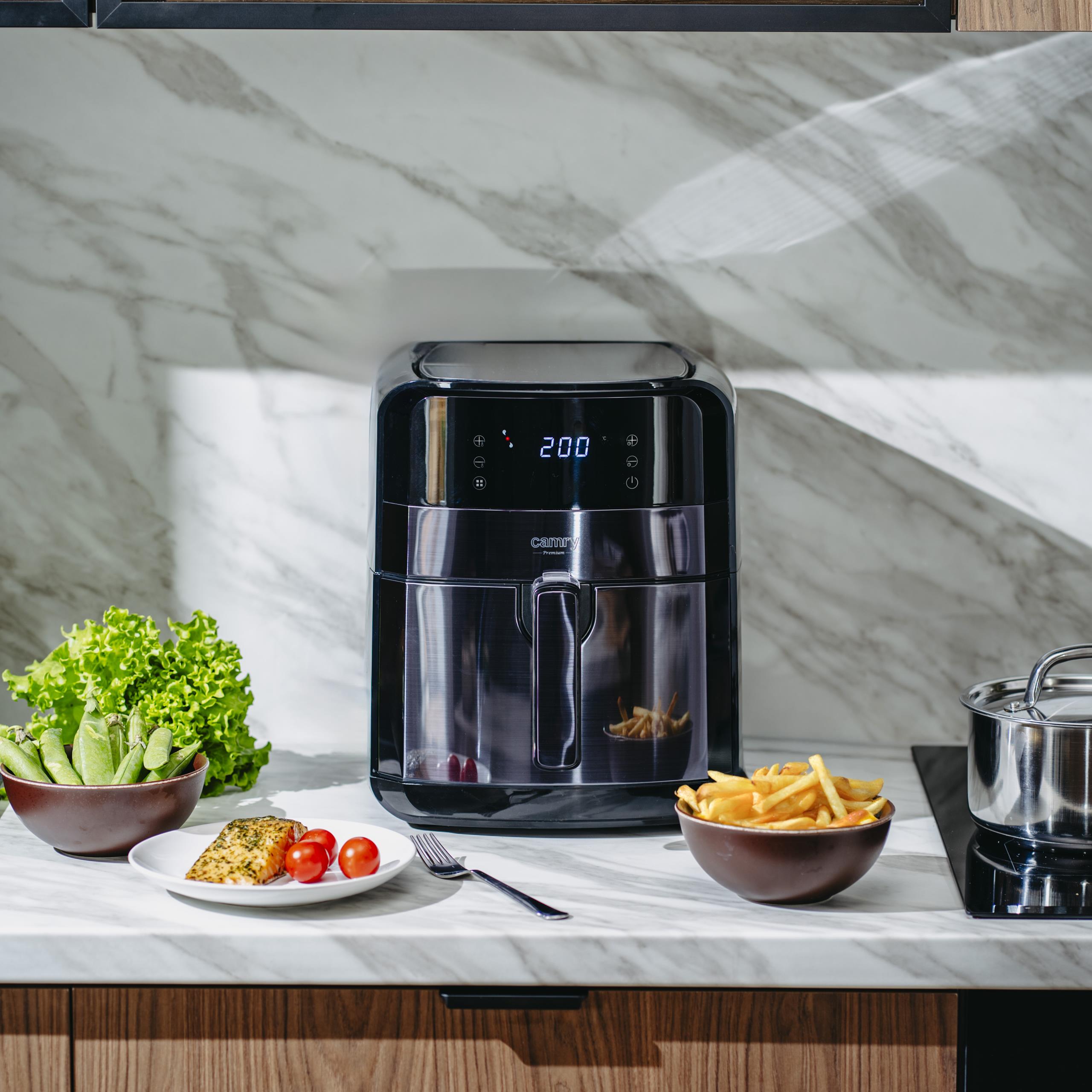 Widok frytkownicy beztłuszczowej z koszem częściowo wysuniętym, ukazujący nienagrzewający się uchwyt