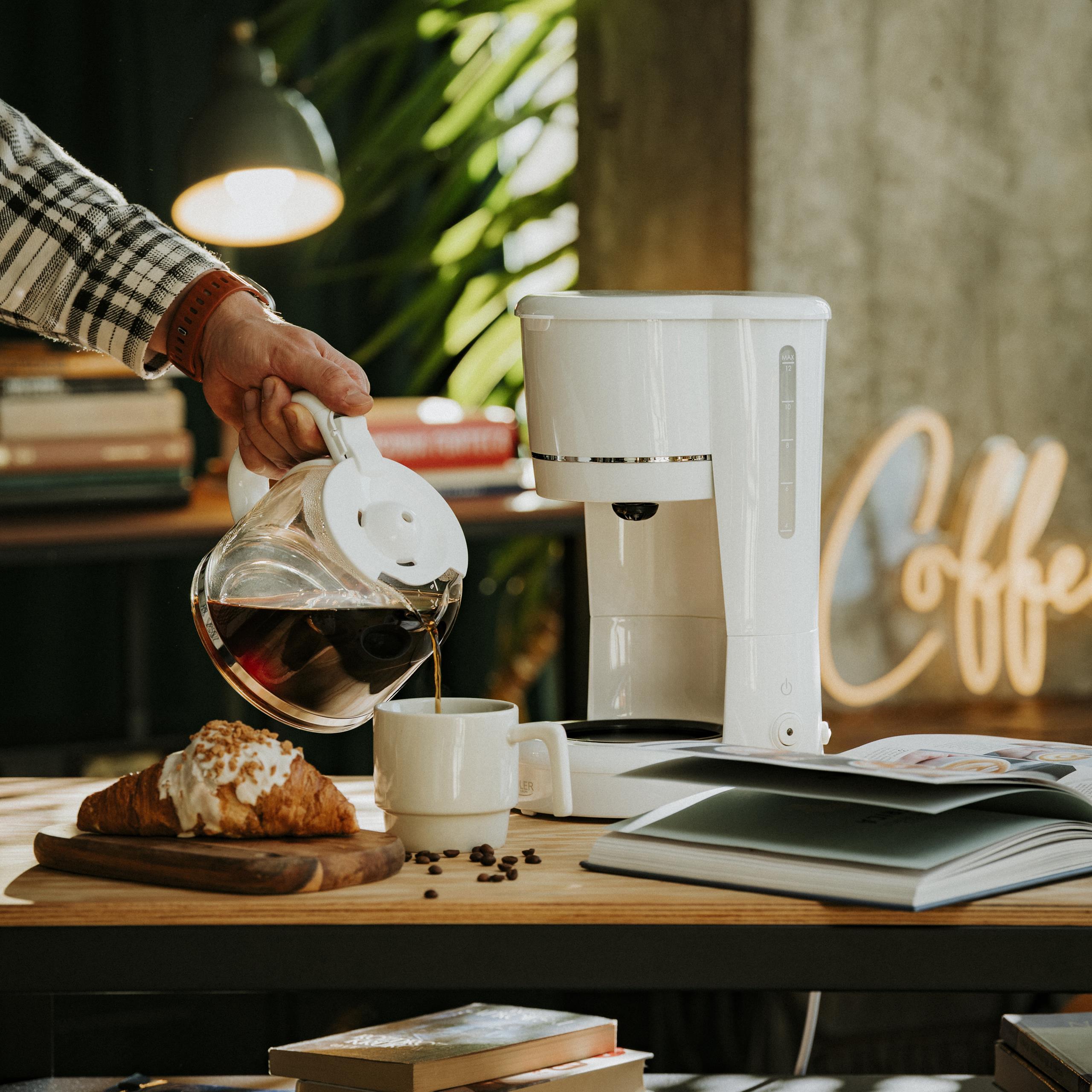 Ekspres Adler AD 4383 na kuchennym blacie, z filiżanką kawy obok, symbolizujący poranną rutynę.