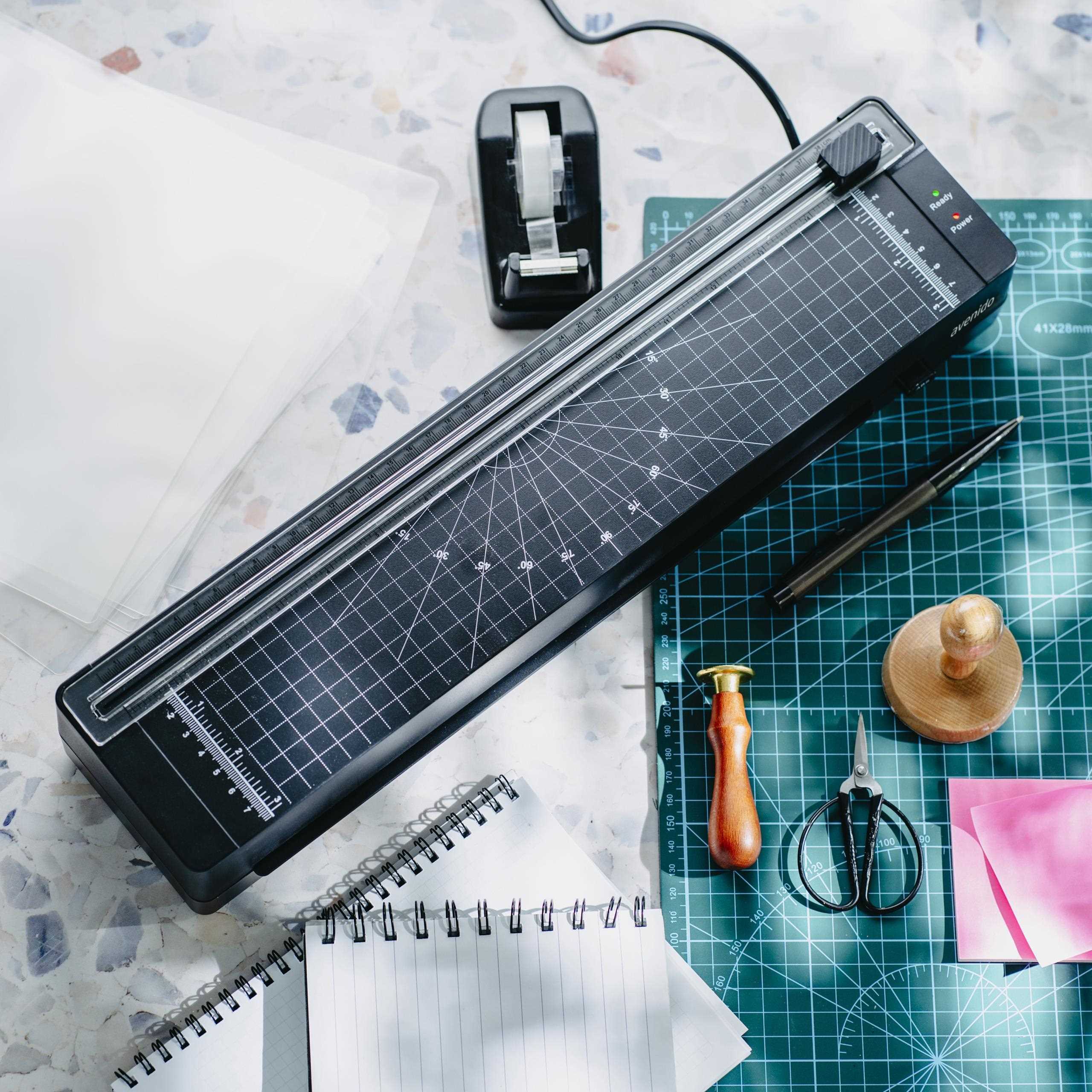 Szczegółowy widok na wbudowany trymer laminatora Avenido, z miarką i ostrym nożykiem tnącym