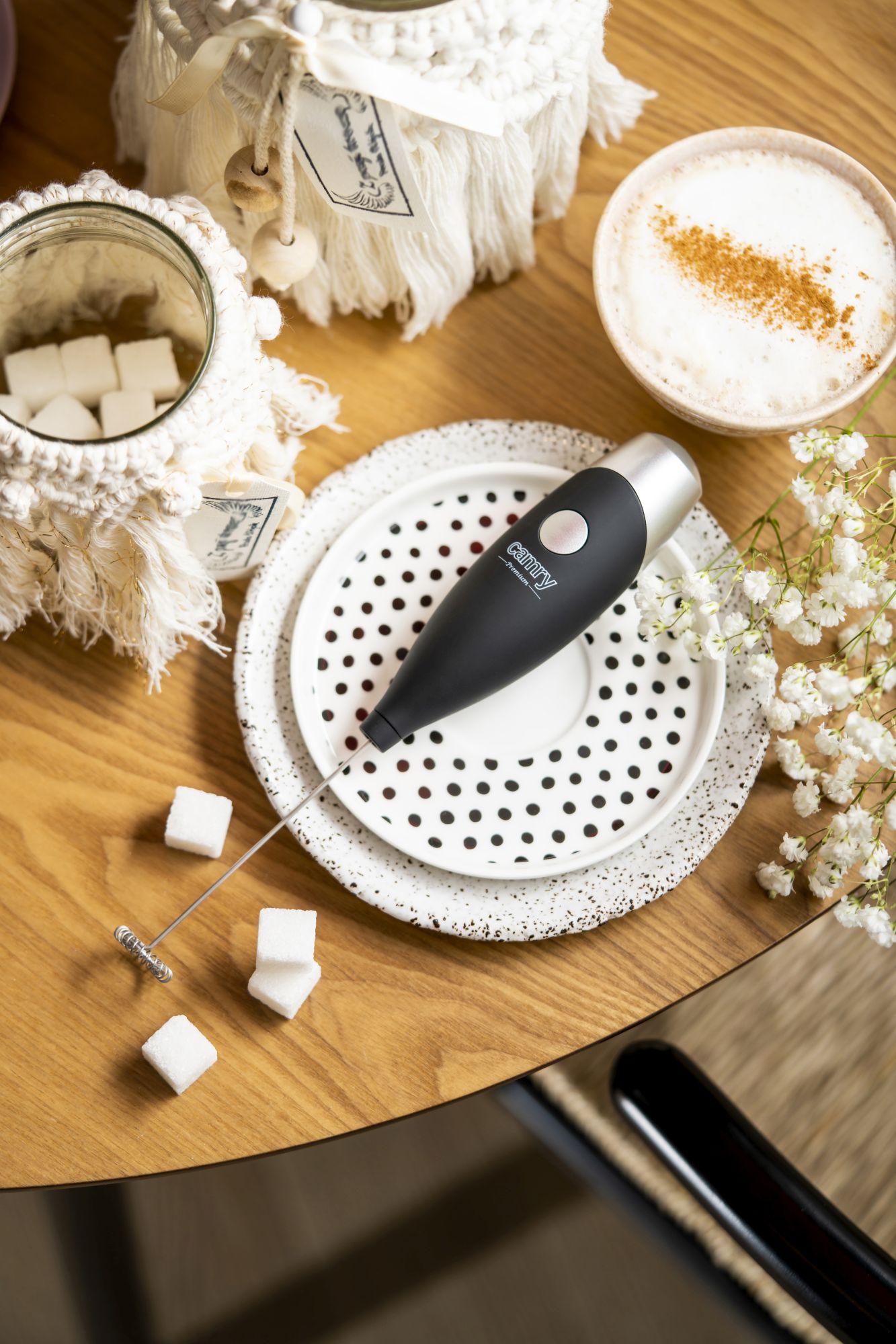 Ręczny spieniacz do mleka Camry CR45011 w akcji, spieniający mleko w kubku, z widoczną puszystą pianką.