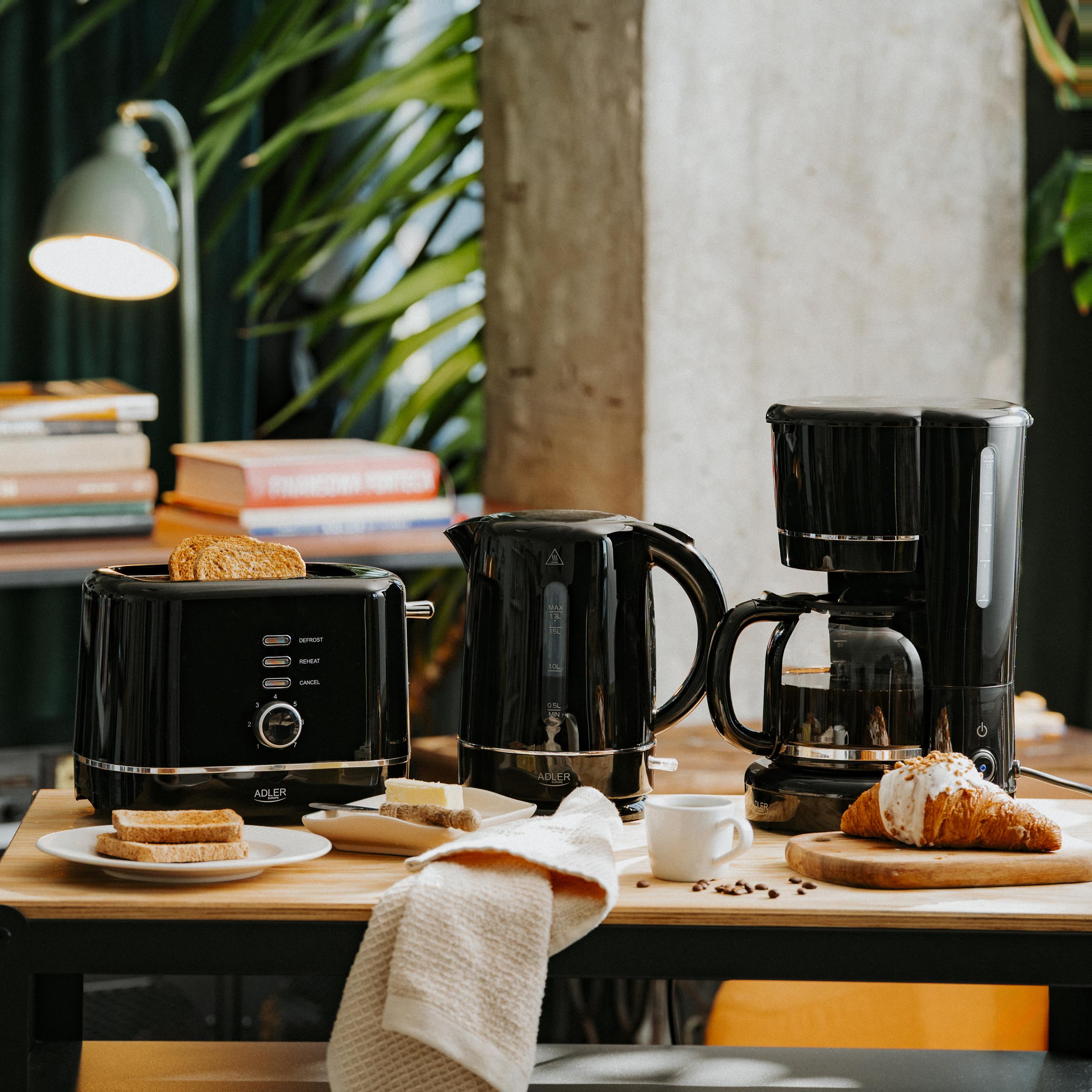 Czarny zestaw kuchenny Adler w nowoczesnej kuchni, prezentujący ekspres do kawy, czajnik i toster w akcji