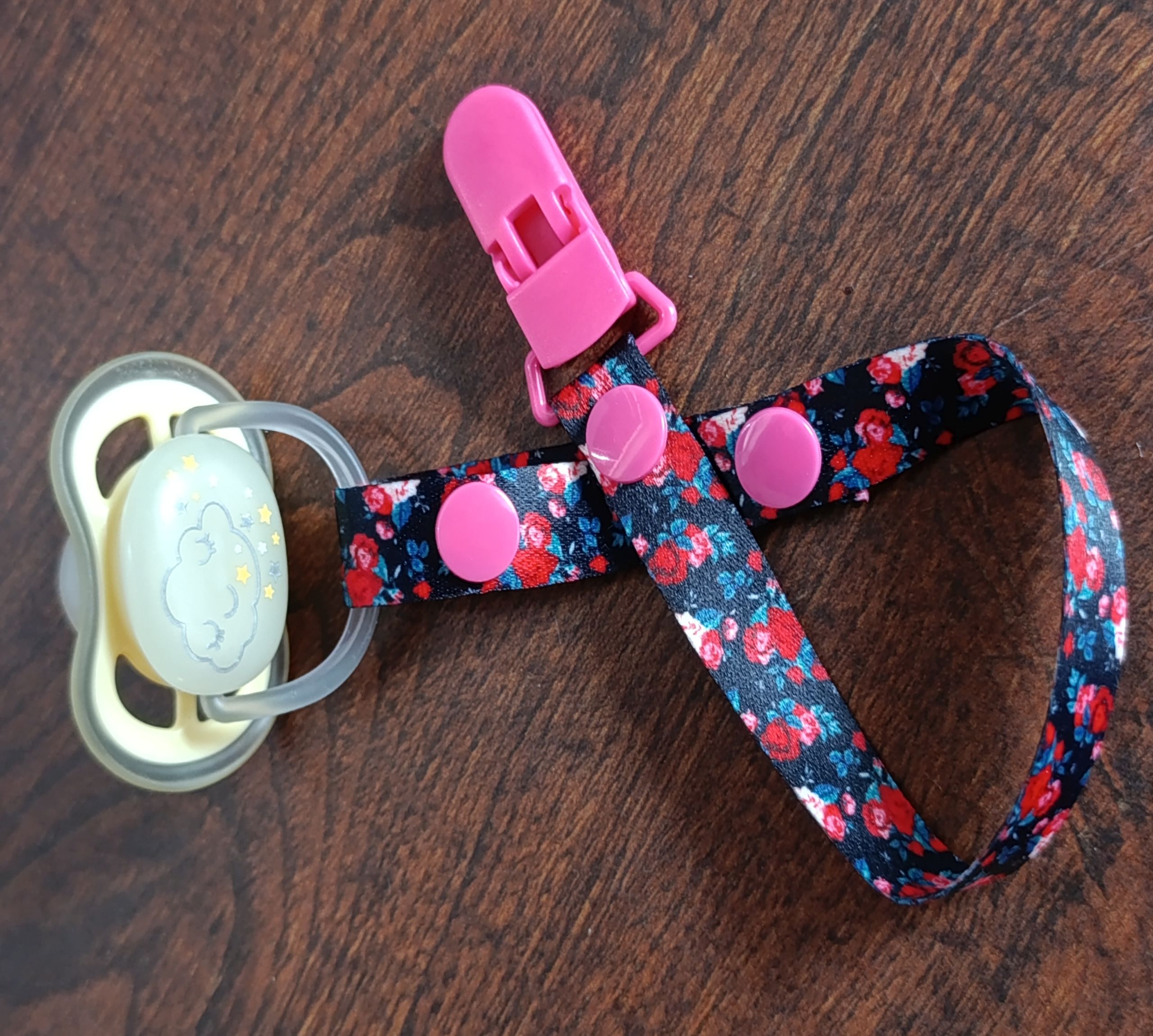 zawieszka do smoczka kwiaty prezentacja przy ubranku dziecka